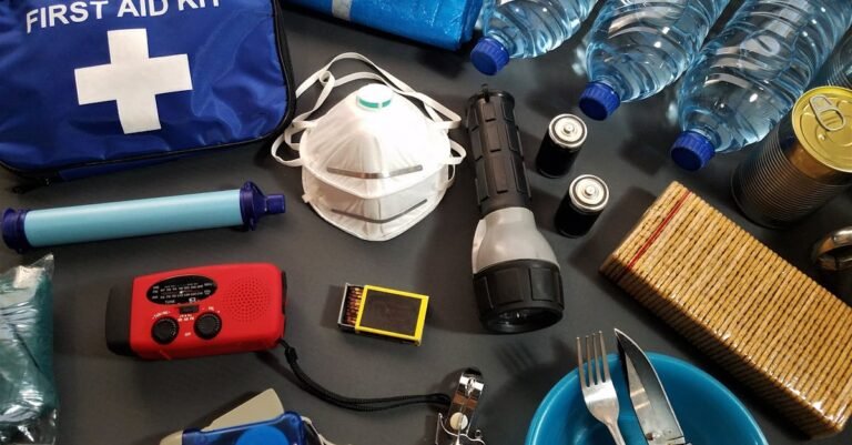 Flat lay of essential emergency survival kit items including first aid and water bottles.