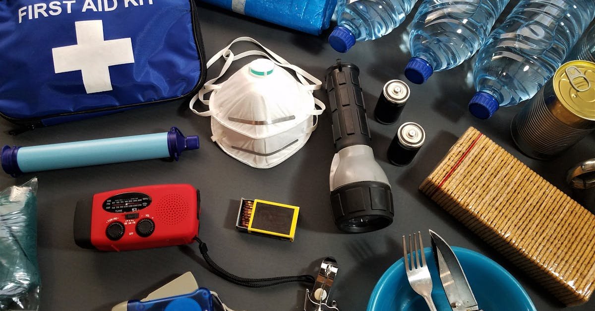 Flat lay of essential emergency survival kit items including first aid and water bottles.
