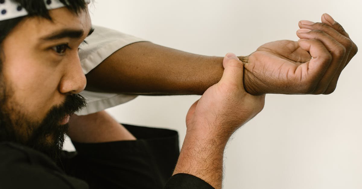 Two martial artists practicing grappling techniques in a dojo setting. Focus on self-defense and training.