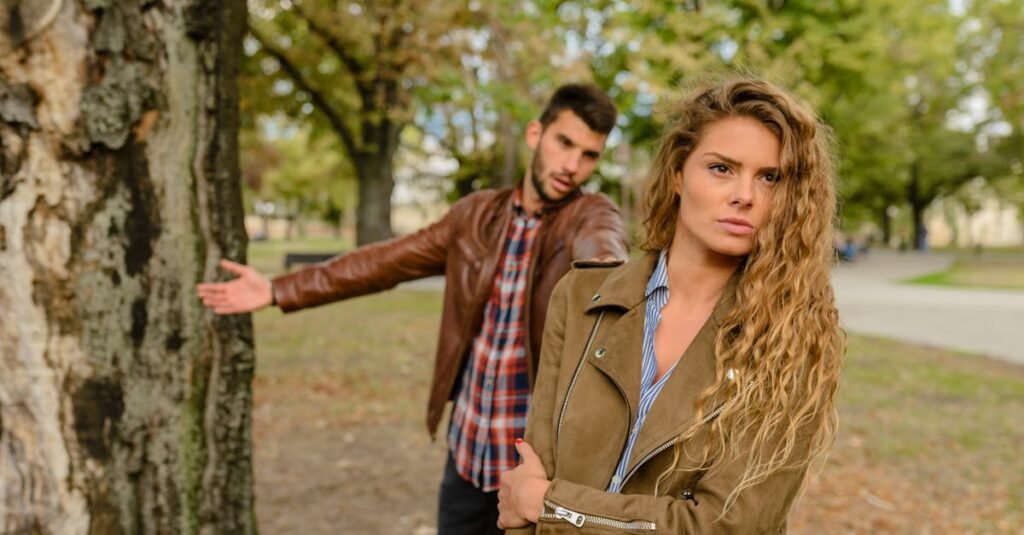 A man and woman in a heated argument outdoors, expressing emotions.